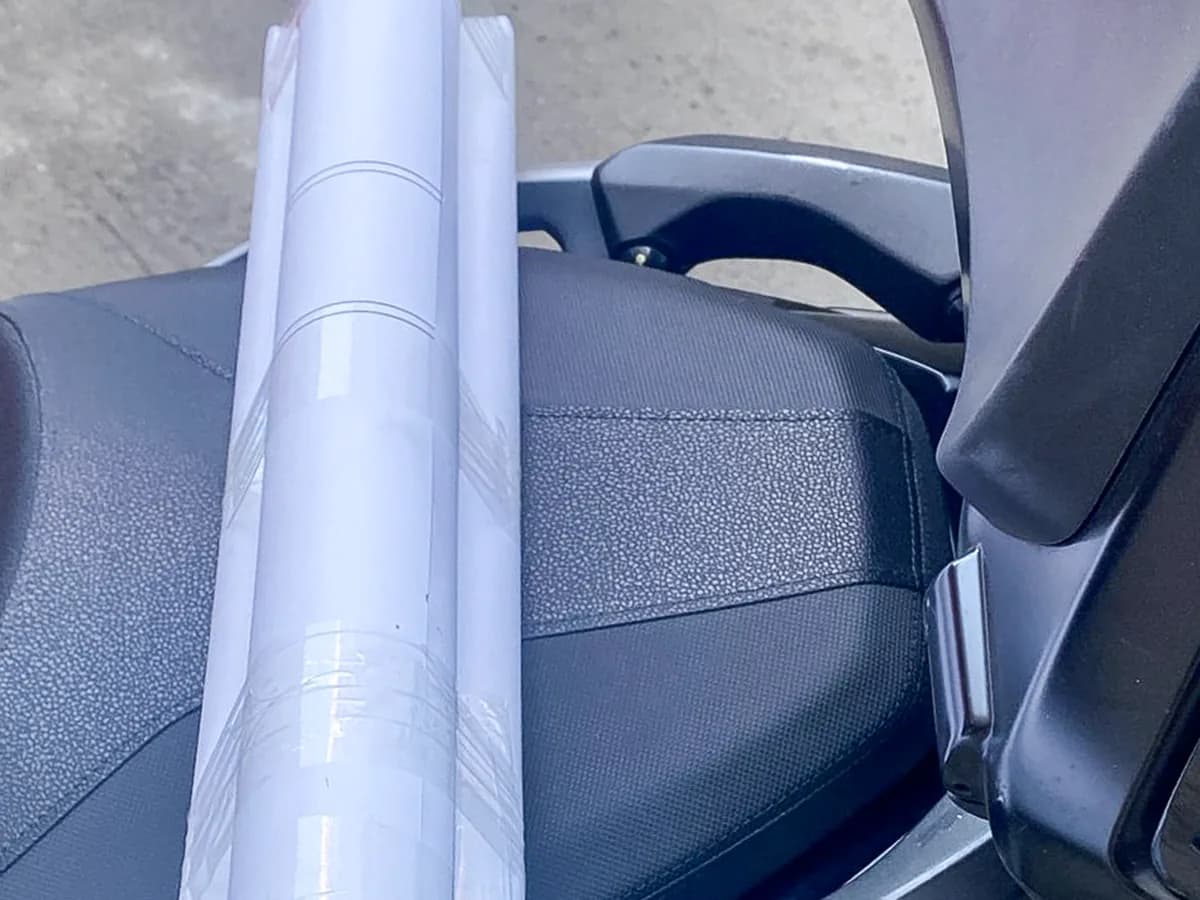 Motosikletin üzerindeki paketlenmiş rulo afiş