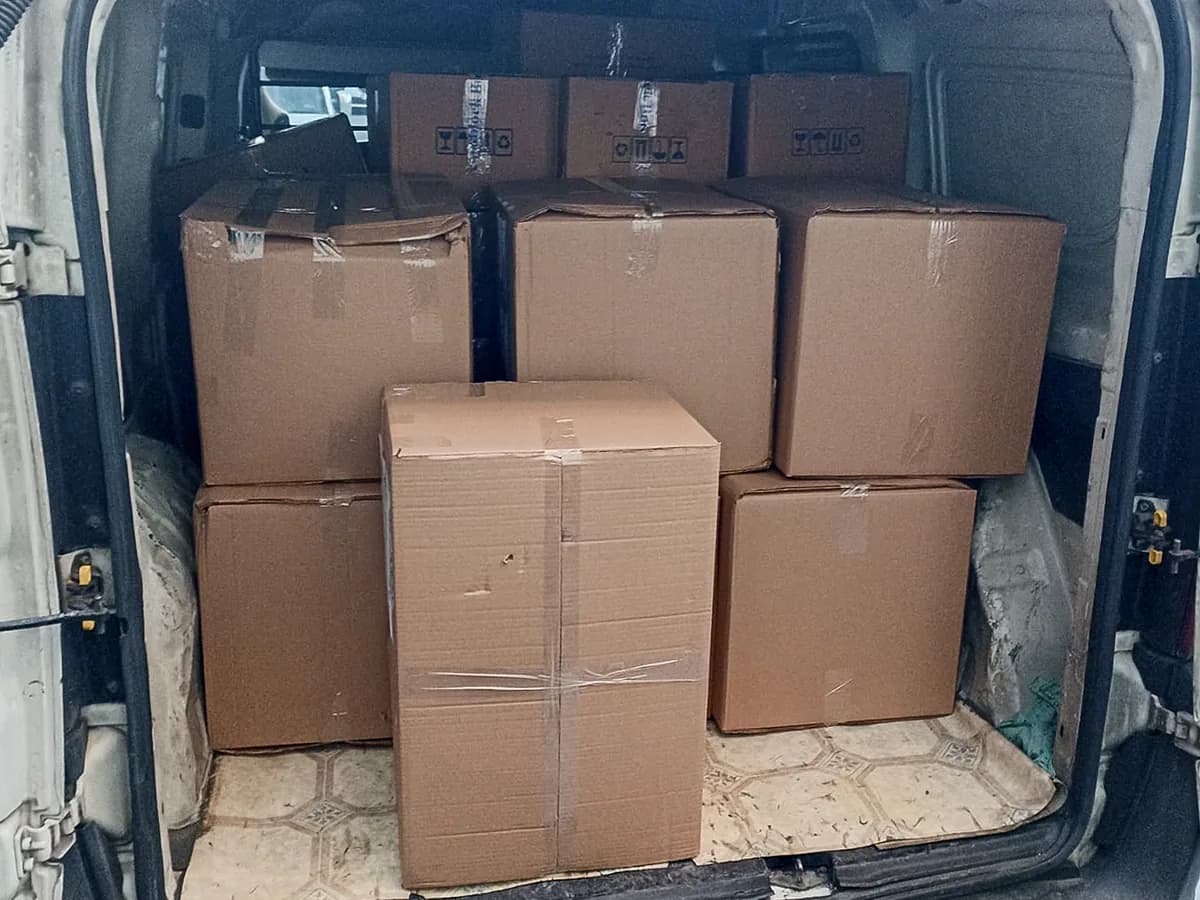 Hafif ticari aracın yük bölümündeki paketlenmiş matbaa kolileri